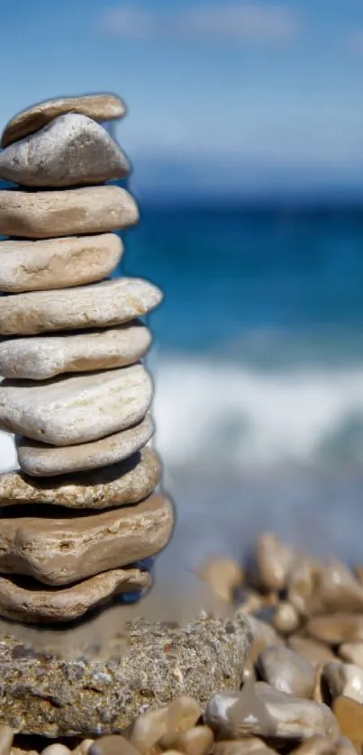 Stacked stones by the ocean with a blue sky background.