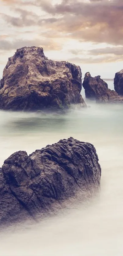 Peaceful coastal scenery with rocks and ocean under a cloudy sky.