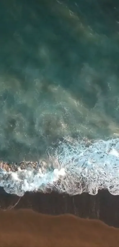 Aerial view of serene ocean waves hitting the sandy beach.