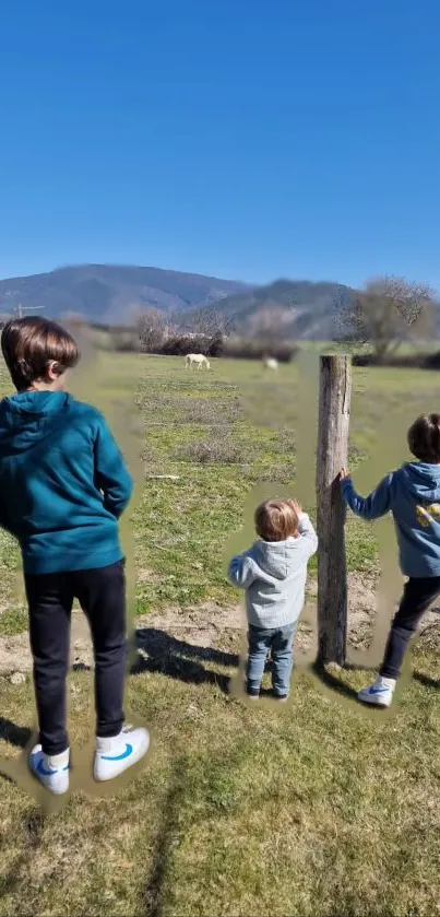 Children enjoying a scenic countryside view with blue sky.