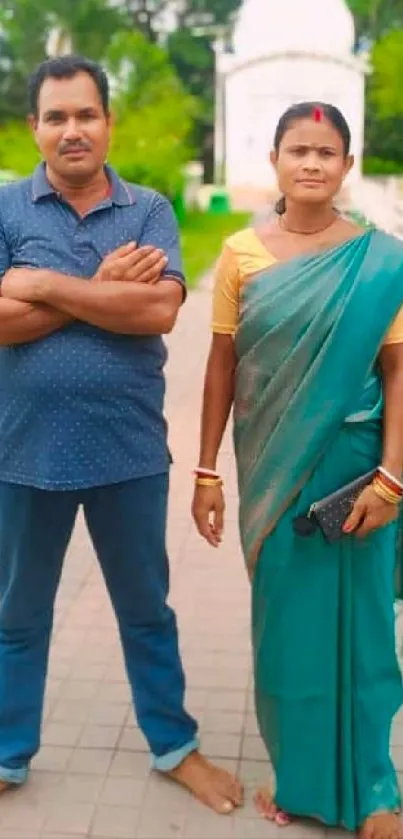 Couple in traditional attire walking in a green park