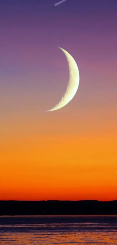 Crescent moon over an orange and purple sunset horizon.