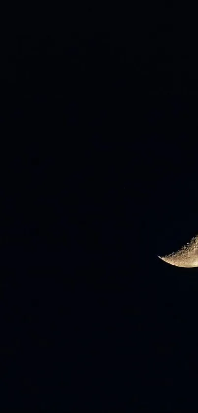 Crescent moon on a dark, serene night sky.
