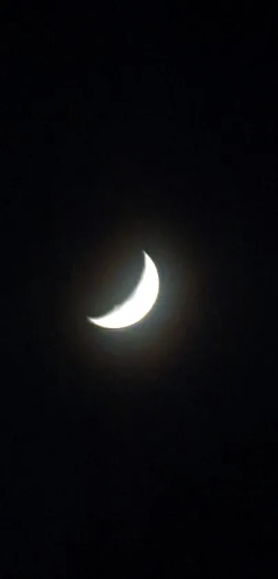 Crescent moon shining in a dark night sky.