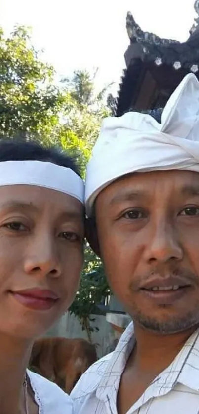 Portrait of a couple in traditional attire with natural backdrop.