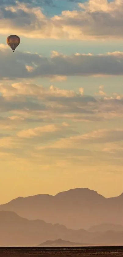 Hot air balloon gliding over mountains at sunrise