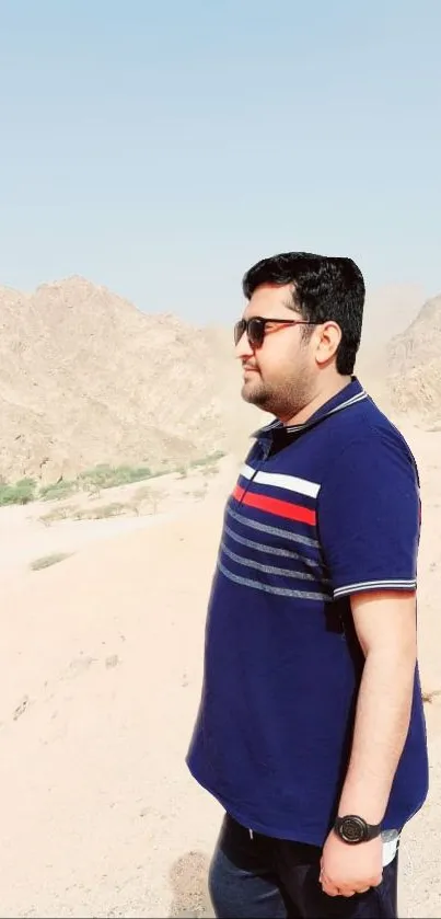 Man exploring serene desert landscape with clear skies and mountains.