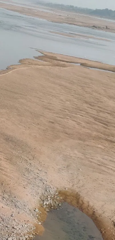 Desert landscape with beige sands and calm water.