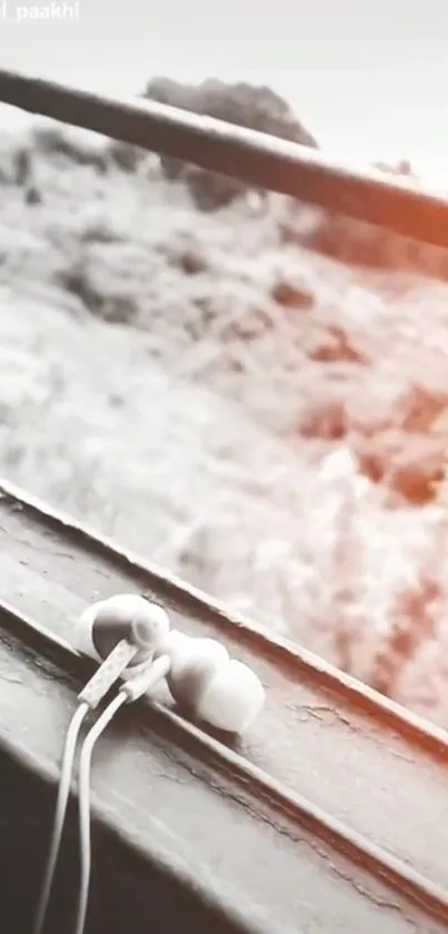 White earbuds resting on a wooden windowsill with a soft, warm background.