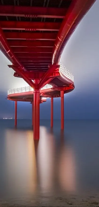 Underneath view of a red pier extending over calm ocean waters.