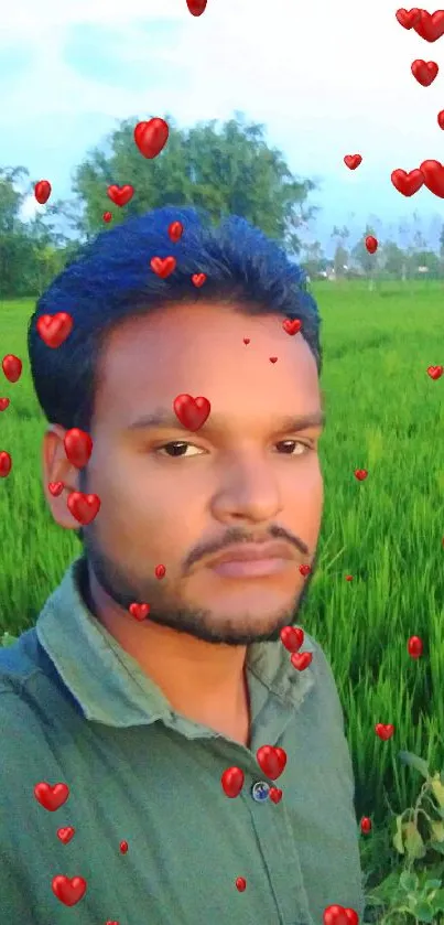 Man in green shirt standing in lush green field with blue sky.