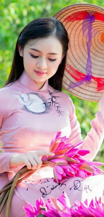 Woman in traditional dress holding pink flowers with a green background.