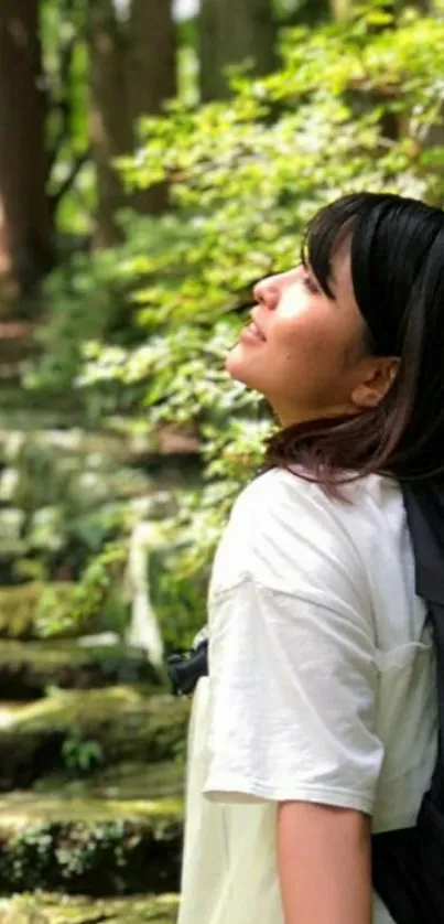 Woman enjoying nature on a forest pathway with lush greenery.