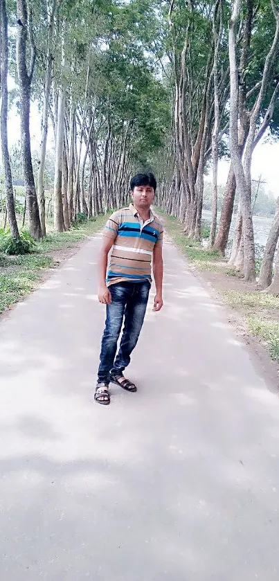 Person standing on green forest pathway with trees lining the sides.