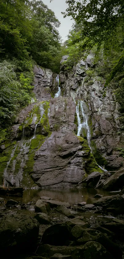 Majestic waterfall cascading down rocky cliffs in a lush green forest.