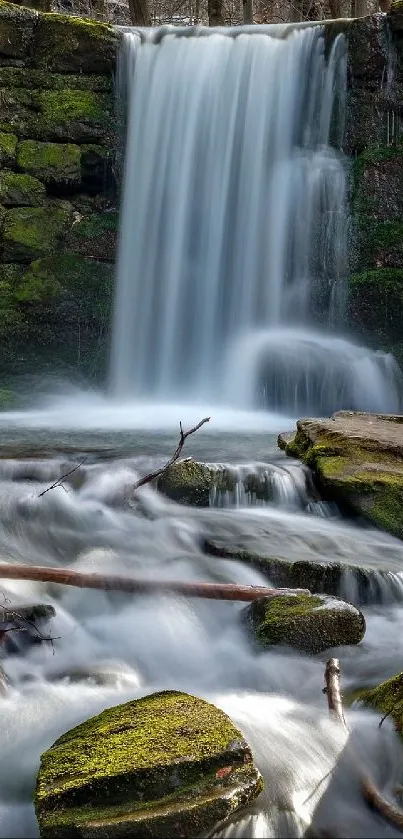 Serene waterfall in forest setting with moss-covered rocks.