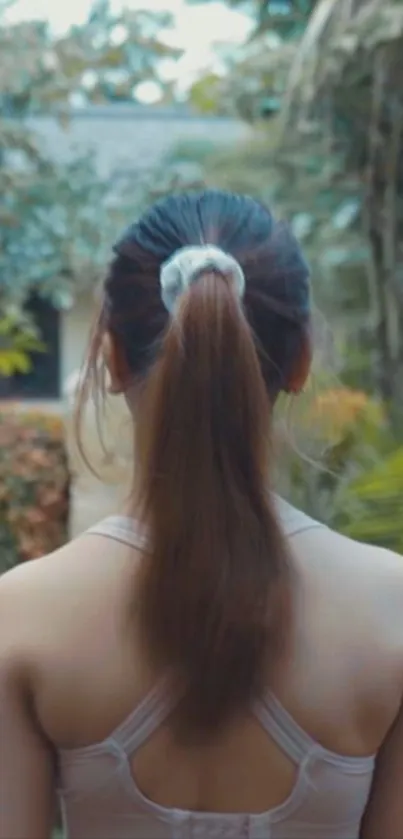 Back view of a woman in a serene garden setting.