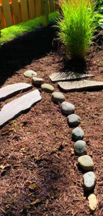 Dragonfly shape made of stones in a garden setting with mulch and grass.