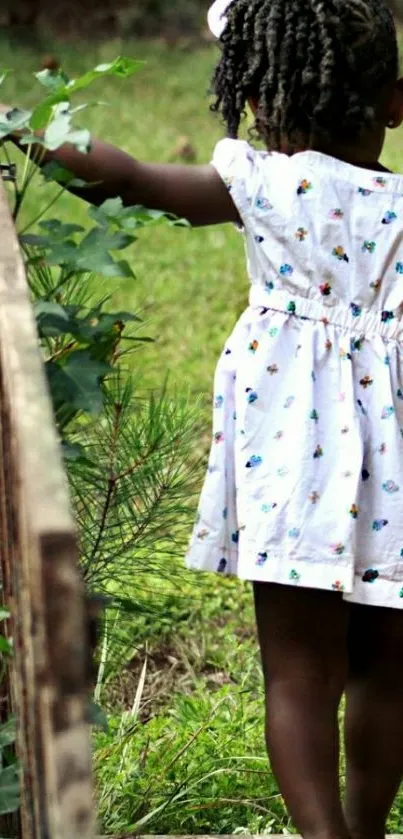 A young girl explores a lush green garden path.