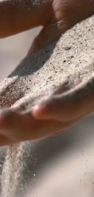 Close-up of sand flowing through hand, creating a serene and natural texture.