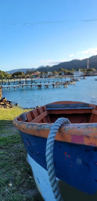 A colorful rowboat by a serene harbor with blue waters and distant hills.