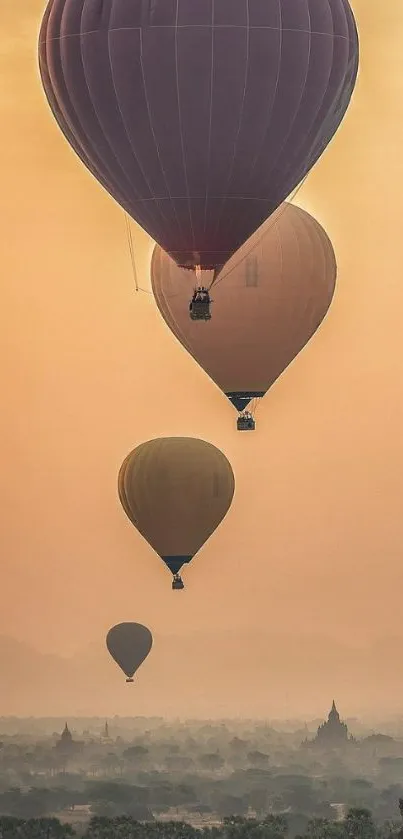 Serene hot air balloons drifting over misty landscape at sunrise.