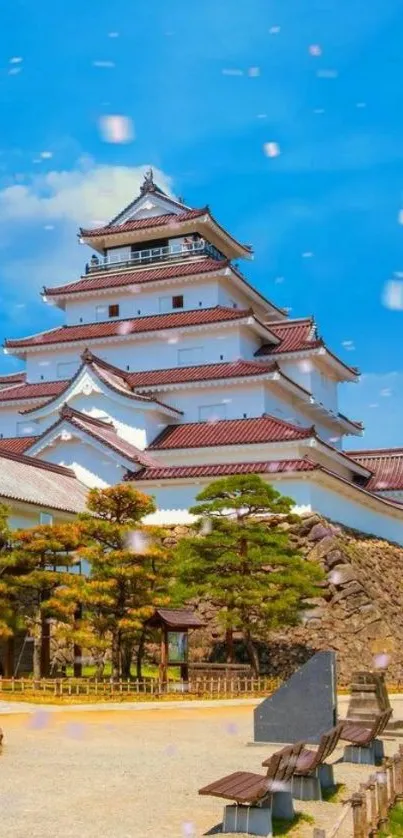 Japanese castle with blue sky and blossoms wallpaper.