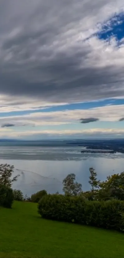 A serene lake with cloudy sky and green landscape.