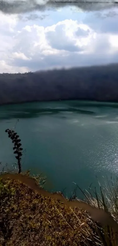 Tranquil lake surrounded by hills under a cloudy sky wallpaper.