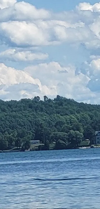 Serene lake with fluffy clouds and lush greenery.