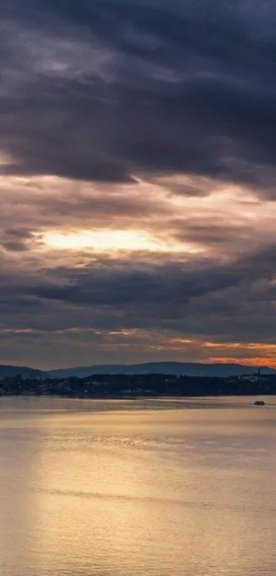 Serene sunset view over a calm lake with dark clouds.