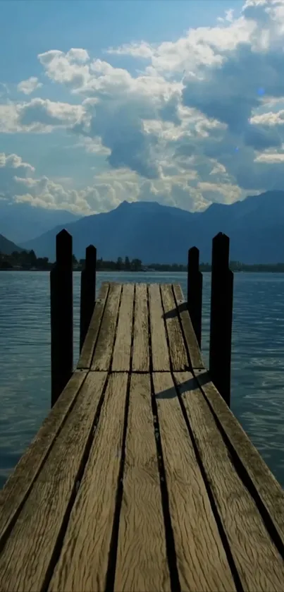 Serene wooden dock extending into a calm lake under blue sky.