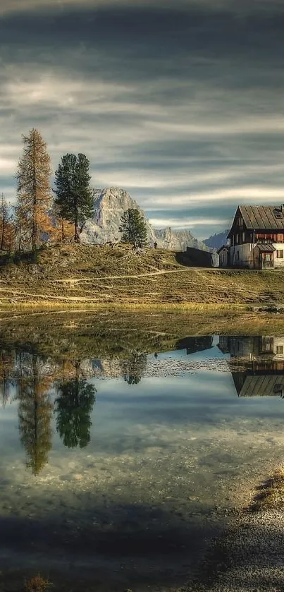 Serene mountain landscape with lake reflection and rustic cabin.