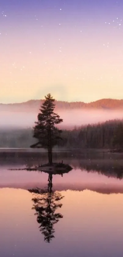 Serene sunset over a lake with a lone tree and misty mountains.