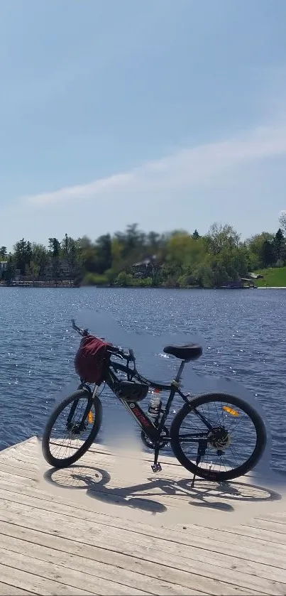 Bicycle on a wooden pier by a tranquil lake under a clear sky.