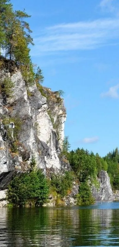 Lakeside cliff with trees under a clear blue sky.