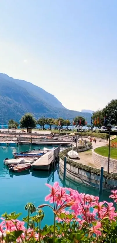 Serene lakeside view with flowers, boats, and mountains under a clear sky.