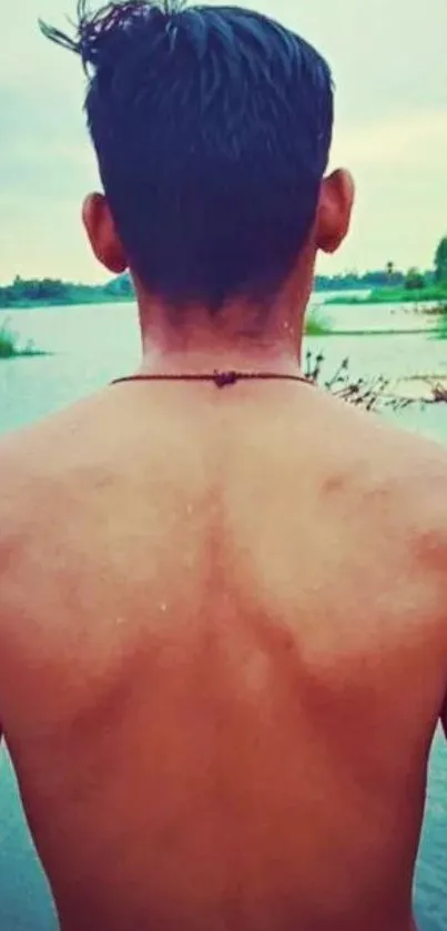 Back view of person at a serene lakeside with a tranquil water scene.