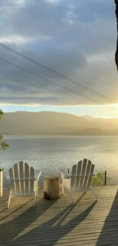 Two chairs overlooking a serene sunrise on a lake.