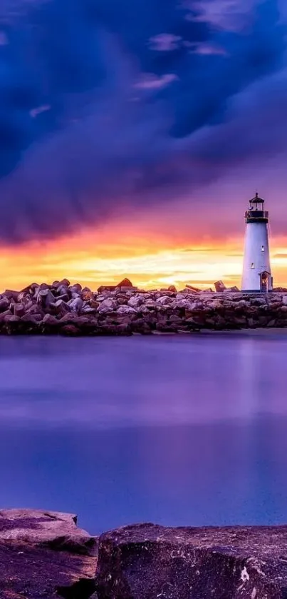 Lighthouse at sunset with vibrant sky over ocean.