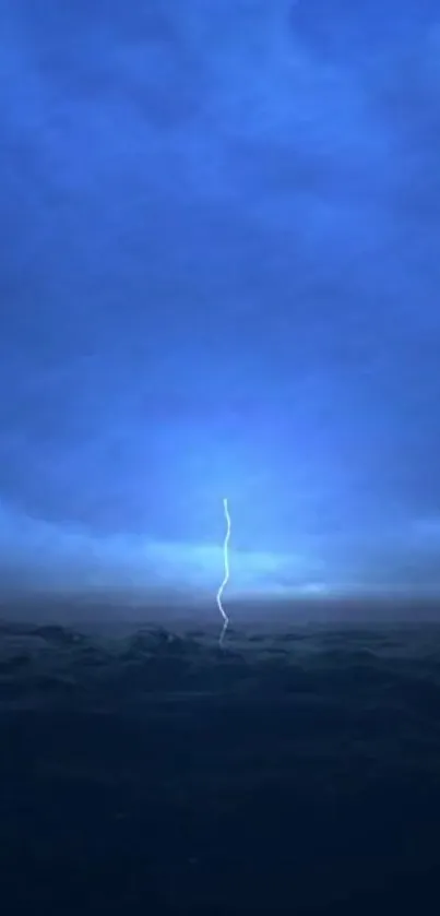 Lightning striking under a vast blue, cloudy sky.