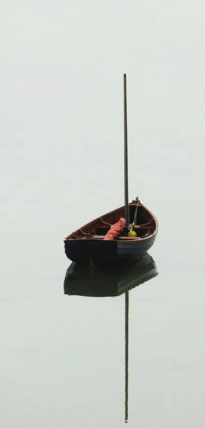 A lone wooden boat reflecting on calm, light gray water.