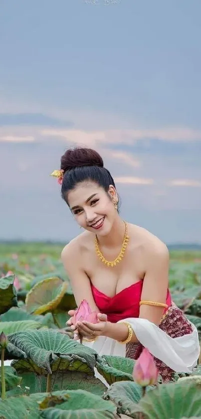 Woman in traditional attire amidst lotus field in serene setting.