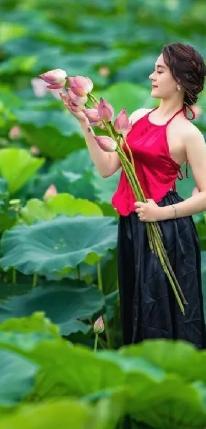 Woman in a red top holding lotus flowers surrounded by green leaves.