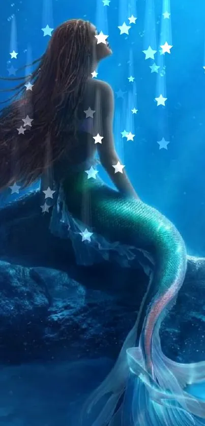 Mermaid with flowing hair in serene blue ocean wallpaper.