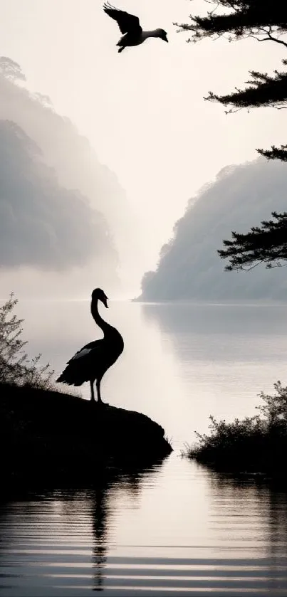 Misty lake with bird silhouettes in a serene landscape.