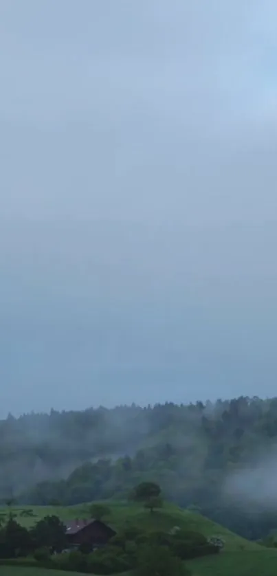 Serene misty landscape with green hills and a cloudy sky.