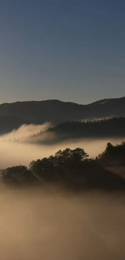 Misty mountain landscape wallpaper with fog and hills at sunrise.