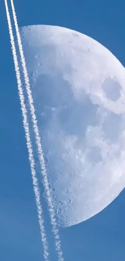 Half moon with vapor trails in a blue sky.