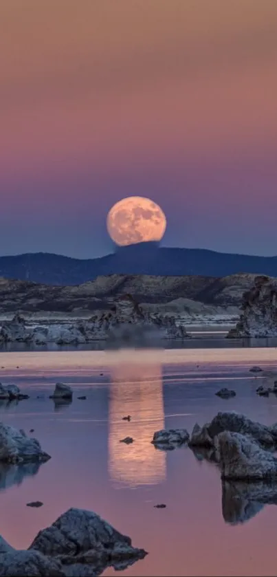 Full moon over tranquil lake at dusk with purple-pink sky.